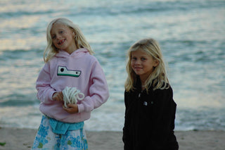 The founders of STOW Apparel as young sisters by the water